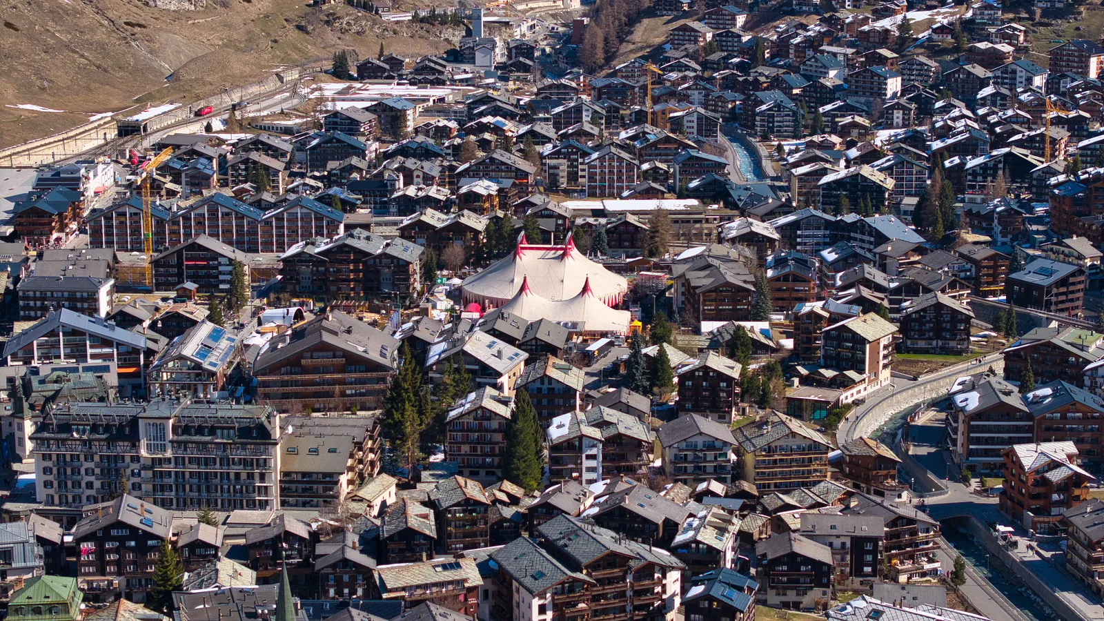 Aerial view of Zermatt village with the white-and-red Zermatt Unplugged festival tent at its centre